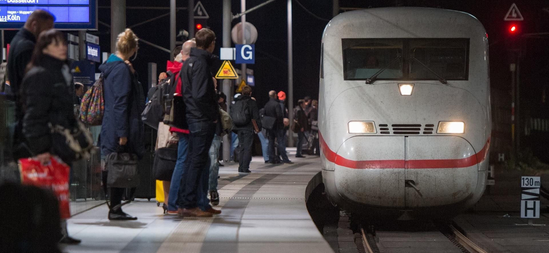 Reisende warten am Berliner Hauptbahnhof auf einen Zug.