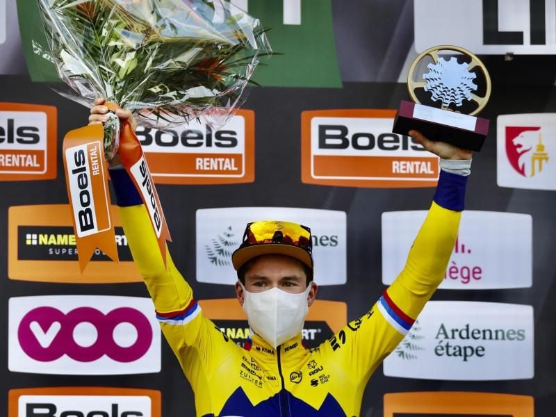 Der Slowene Primoz Roglic vom Team Jumbo jubelt mit Mund-Nasen-Schutz und Pokal bei der Siegerehrung auf dem Podium. Foto: Olivier Matthys/AP/dpa