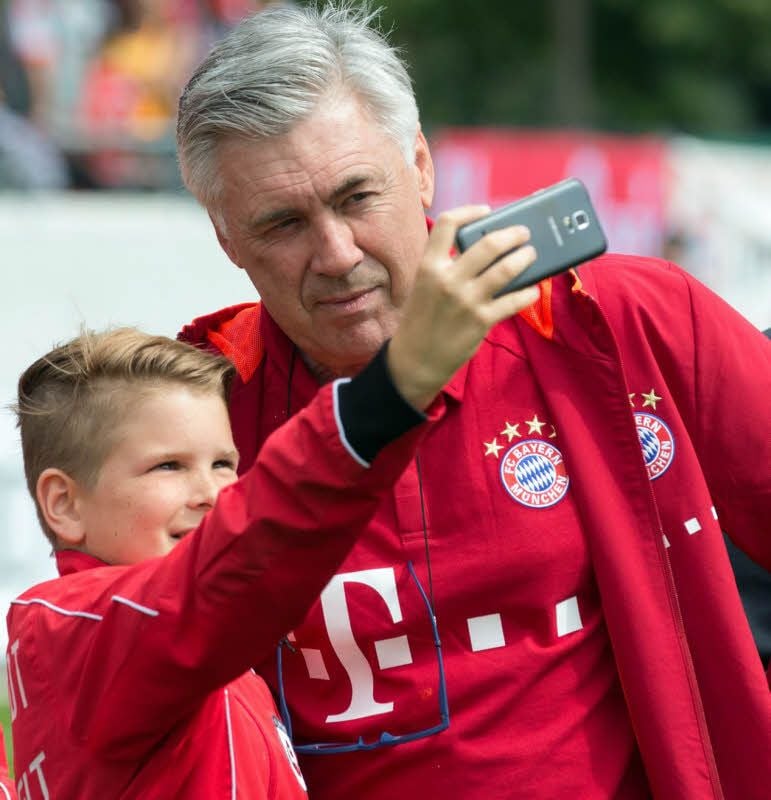 Carlo Ancelotti (r.) posiert beim Test in Lippstadt für ein Foto mit einem jungen Bayern-Fan.