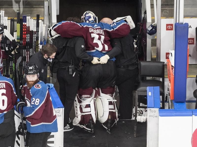 Dem verletzten Torhüter Philipp Grubauer (M) von den Colorado Avalanche wird in die Umkleidekabine geholfen. Foto: Jason Franson/The Canadian Press/AP/dpa
