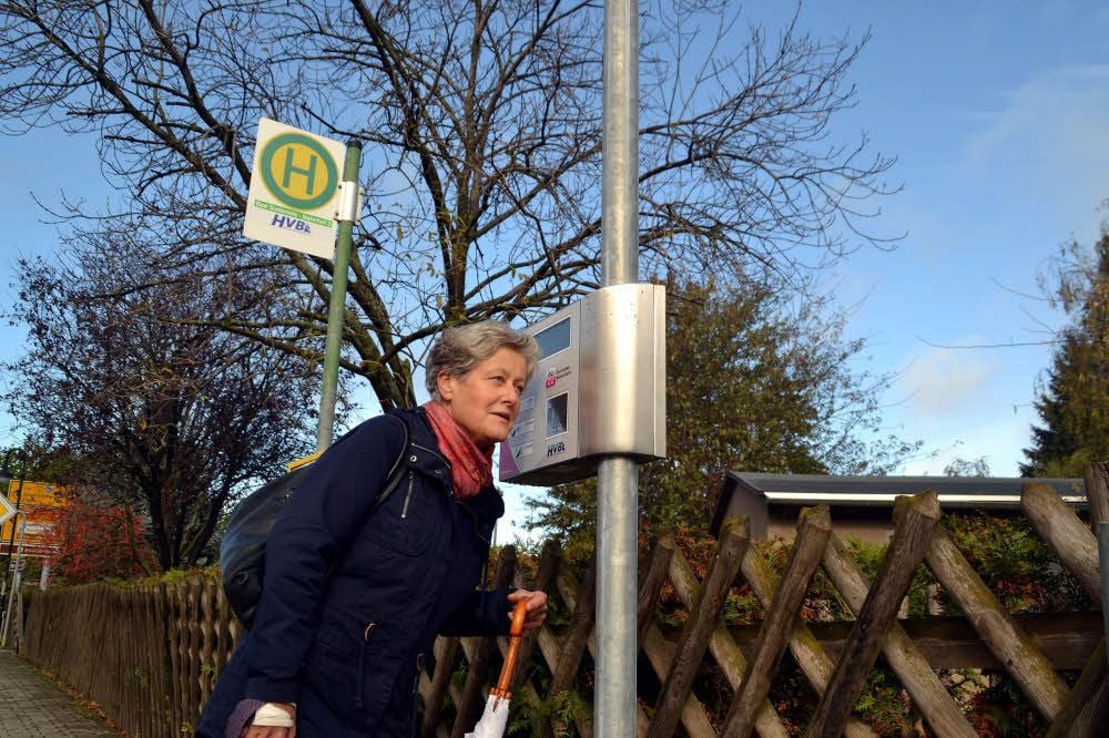 Ein Frau lauscht der Ansage an der Bushaltestelle in Bad Suderode.