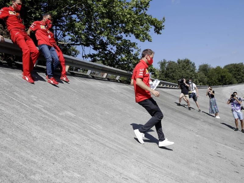 Ferrari-Pilot Sebastian Vettel läuft die Steilkurve der alten Rennstrecke von Monza ab. Foto: Luca Bruno/AP/dpa