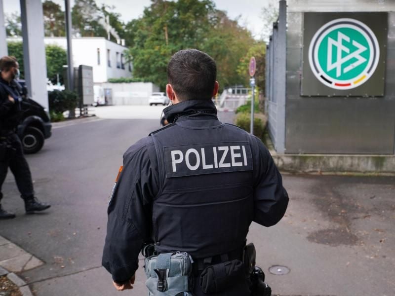 Ein Polizist steht vor der DFB-Zentrale in Frankfurt/Main. Wegen des Verdachts der Steuerhinterziehung wurden die Geschäftsräume des DFB durchsucht. Foto: Frank Rumpenhorst/dpa