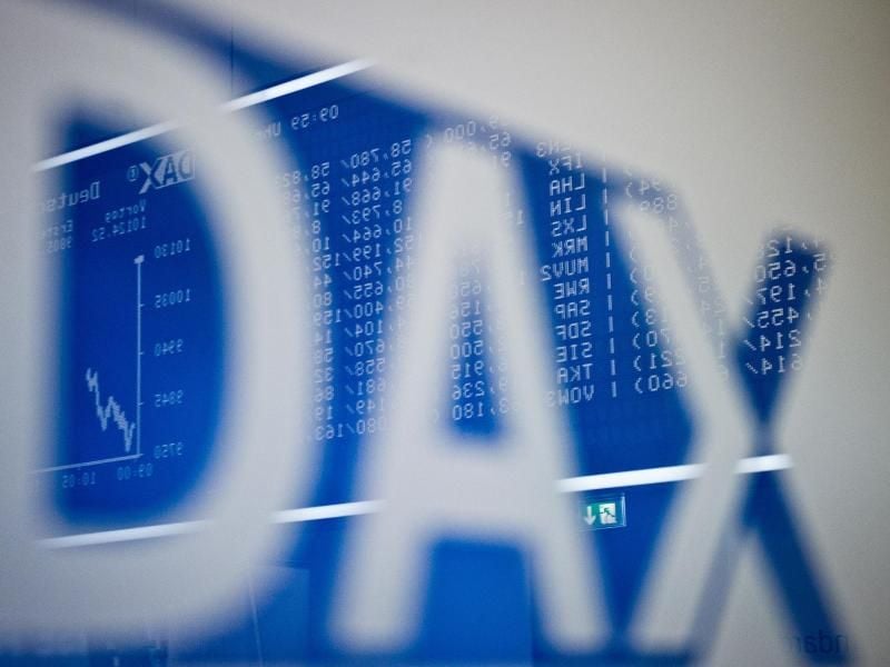 Im Schriftzug "DAX" spiegelt sich die große Anzeigetafel mit dem bis dahin erreichten Kursverlauf im Handelssaal der Börse in Frankfurt am Main. Foto: Christoph Schmidt