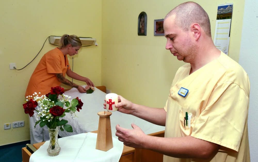 Die Pflegerin Madlen Kemp und der Pfleger Patrick Hickethier bereiten ein Zimmer zur Aussegnung vor.