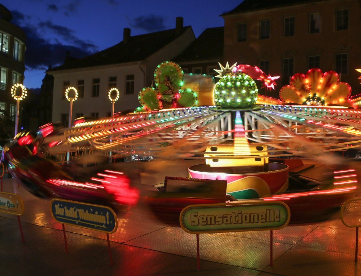 Ein Karussell mit bunten Lichtern dreht sich auf dem Oktoberfest.