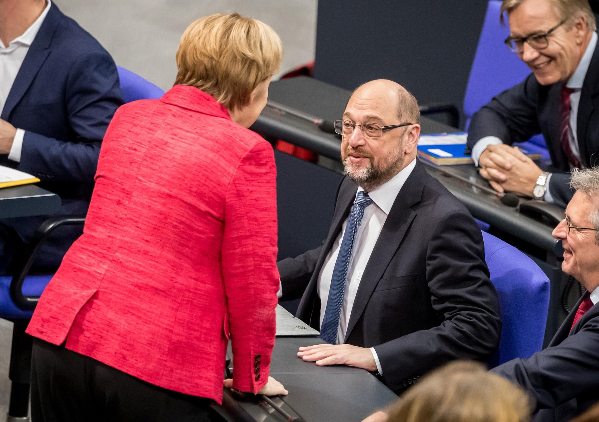 Merkel und Schulz sprechen im Bundestag miteinander.