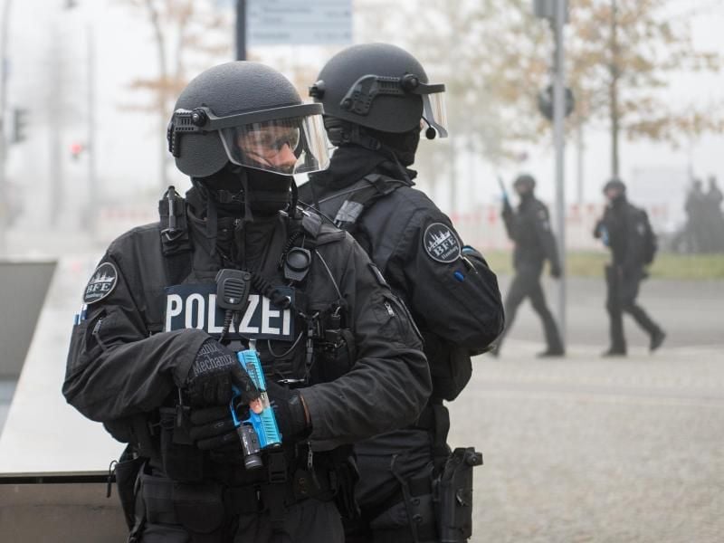 Schwer bewaffnete Polizeikräfte sichern während einer Anti-Terror-Übung einen Bahnhofseingang. Foto: Daniel Bockwoldt