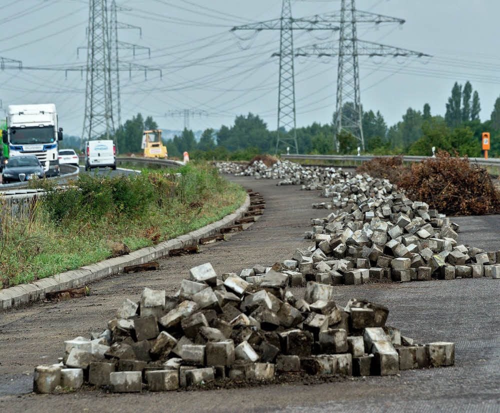 Die Steine der alten Bordrinne wurden aus der Straße geholt. Auch Buschwerk musste entfernt werden, damit gearbeitet werden kann. Zum Straßenbau gehört eben viel mehr als nur eine Asphaltdecke.