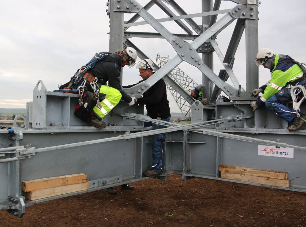 Arbeiter der Spezialfirma bei der Montage des provisorischen Masts. Er wird solange verwendet, bis ein neuer errichtet ist.