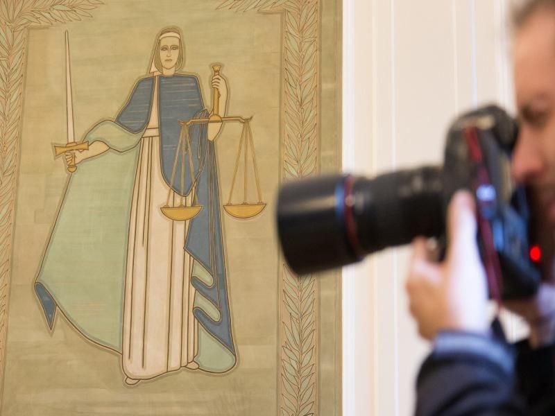 Ein Fotograf vor dem Bild der Justitia. Foto: Friso Gentsch/Archivbild