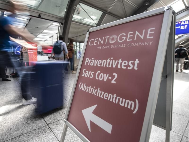 Passagiere gehen am Flughafen Frankfurt am „Flughafen-Corona-Test”-Zentrum vorbei. Foto: Boris Roessler/dpa/Archivbild
