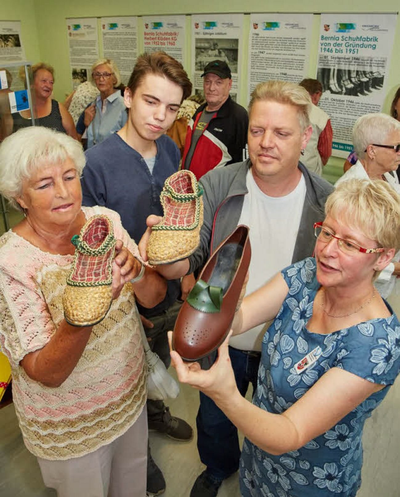 Rosemarie Klöden (von links), ihr Enkel Max, ihr Sohn Martin und Sabine Seifert zeigen Stroh- und Igelitschuhe, die vor mehr als 70 Jahren im Bernburger Unternehmen hergestellt worden sind.