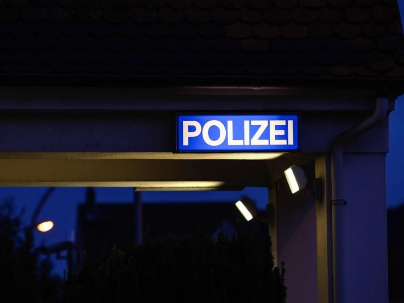 Ein Schild mit der Aufschrift „Polizei” leuchtet am Eingangsbereich der Polizeistation. Foto: Silas Stein/dpa/Symbolbild