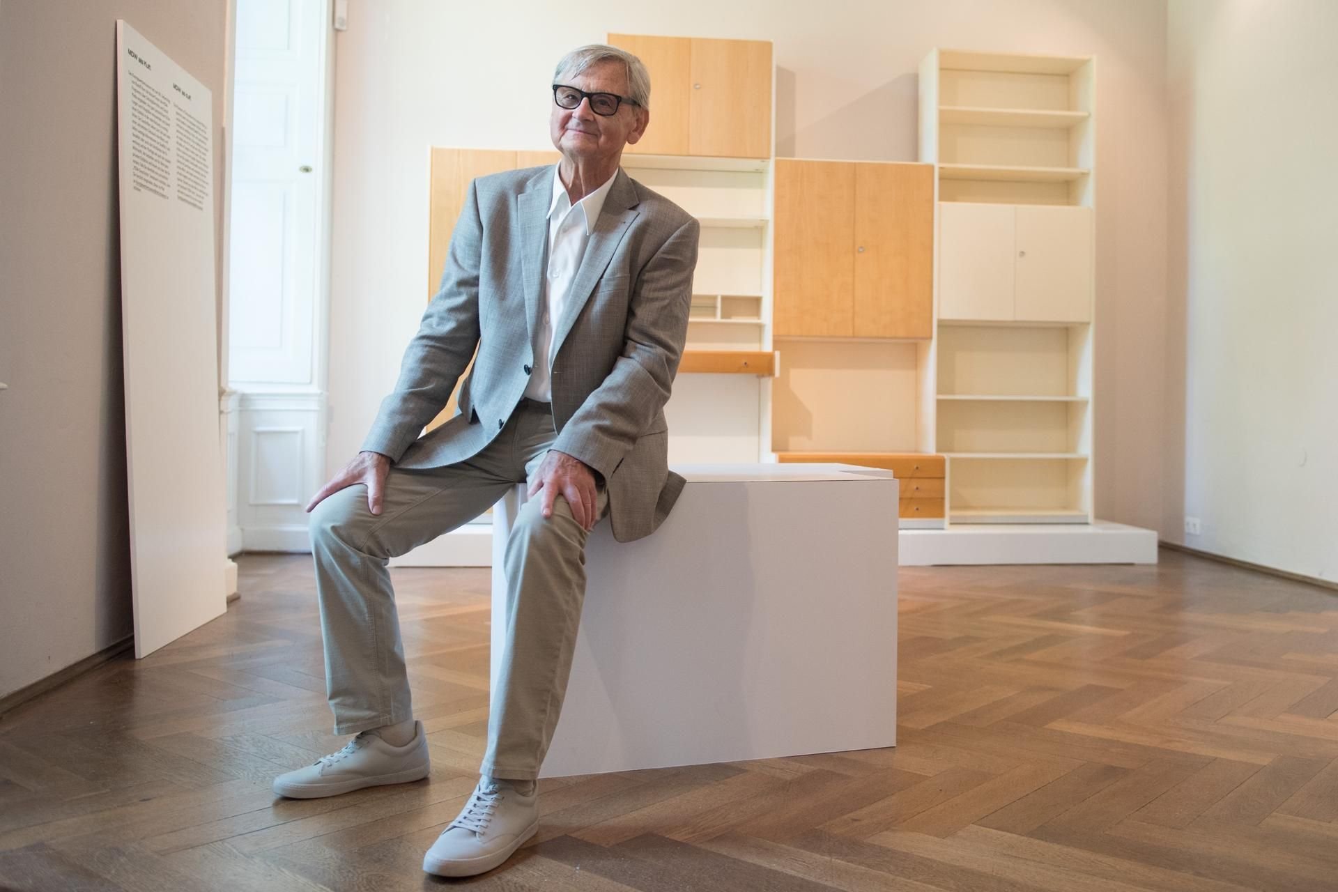 Rudolf Horn, deutscher Möbeldesigner, sitzt im Kunstgewerbemuseum in der Ausstellung "Rudolf Horn - Wohnen als offenes System" vor einer Schrankwand aus dem Möbelprogramm Montagemöbel der Deutschen Werkstätten (MDW).