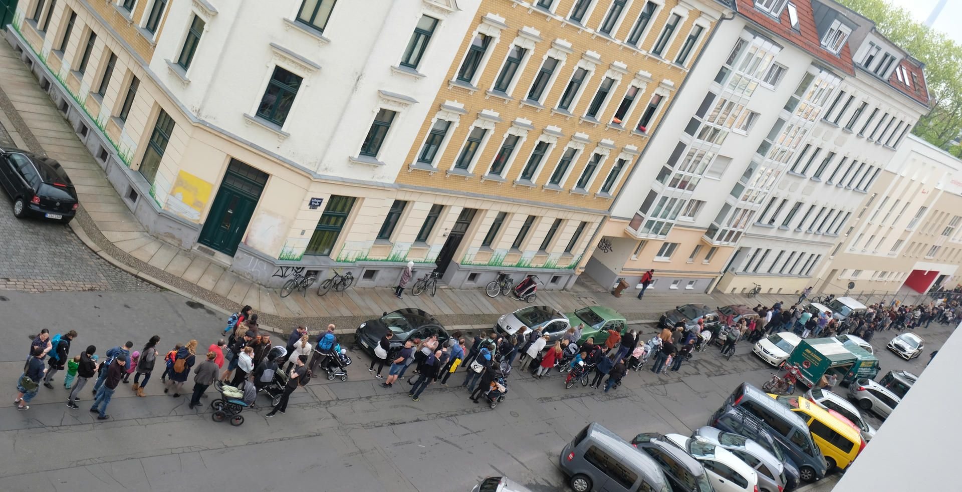 Mehrere hundert Menschen stehen in Leipzig an einer im Bau befindlichen Kindertagesstätte der Johanniter-Unfall-Hilfe e.V. an, um einen Platz zu bekommen.