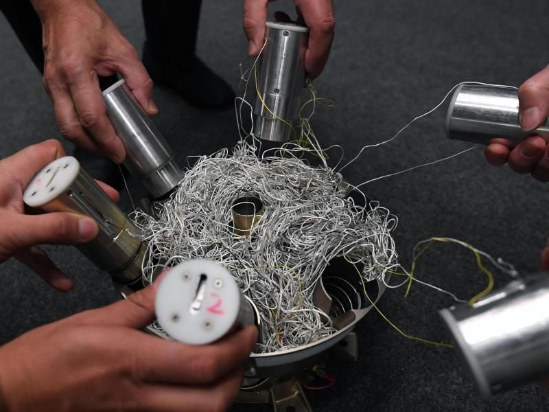 Mitarbeiter von Airbus Defence und Space ziehen die Enden von einem Netz auseinander, das entwickelt wurde um Weltraumschrott im All einzufangen. Foto: Carmen Jaspersen