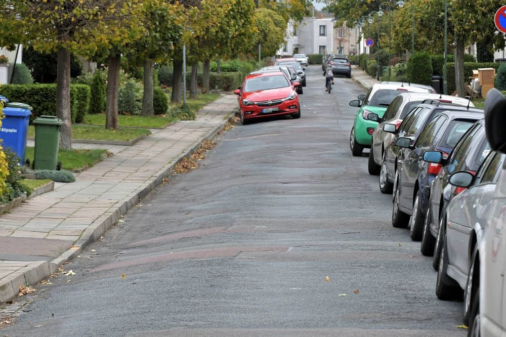Zu den Seiten hin abschüssig und die Oberfläche ein Flickenteppich: Im kommenden Jahr soll die Doppelreihe in der Bauhaussiedlung neue Kanäle erhalten, ein Ausbau der Straße ist in diesem Zuge aber nicht geplant.
