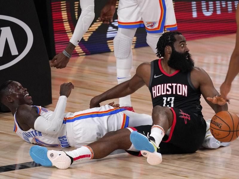Dennis Schröder (l) von den Oklahoma City Thunder und Houstons Star James Harden im Zweikampf. Foto: Mark J. Terrill/AP/dpa