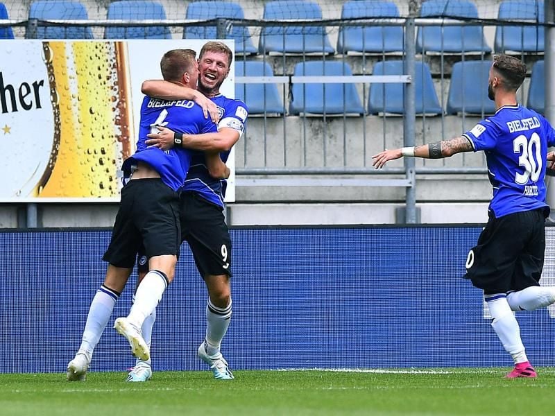 Der Bielefelder Joakim Nilsson lässt sich nach seinem Treffer von Fabian Klos und Marcel Hartel (l-r) feiern. Foto: Revierfoto