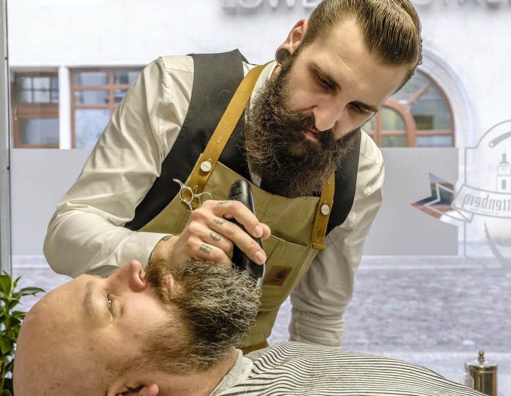 Henning Schulz, selbst Bartträger, kümmert sich nun im Barbershop in der Collegienstraße ganz professionell um Bärte von Kunden, hier Matthias Kühne. Hendrik Hiller hat hier seine vierte Filiale eröffnet.