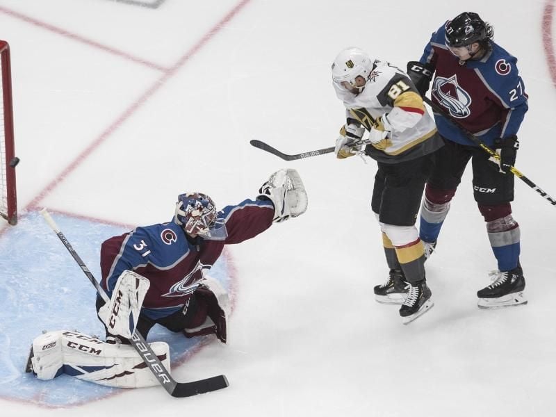 Colorados Torhüter Philipp Grubauer (l) mit Ryan Graves (r) in Aktion gegen Jonathan Marchessault von den Vegas Golden Knights. Foto: Jason Franson/The Canadian Press/AP/dpa