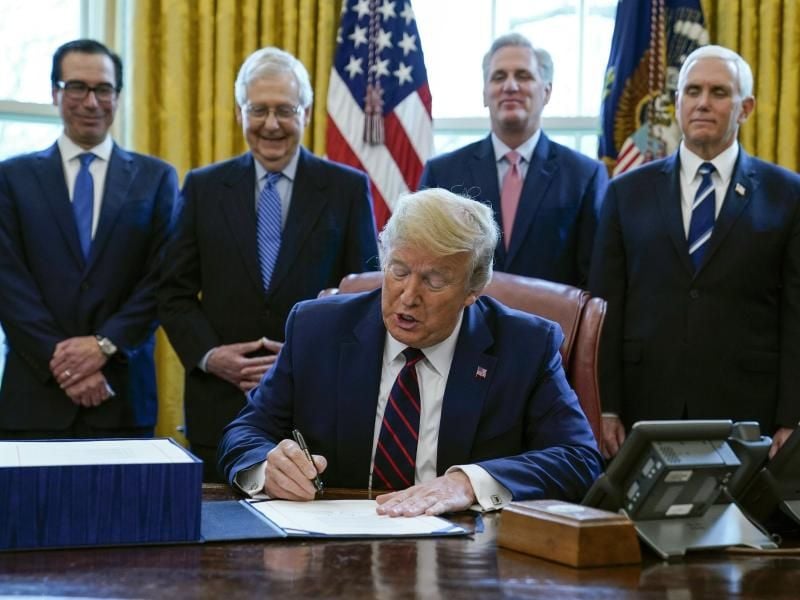 US-Präsident Donald Trump unterzeichnet das Coronavirus-Konjunkturpaket. Foto: Evan Vucci/AP/dpa