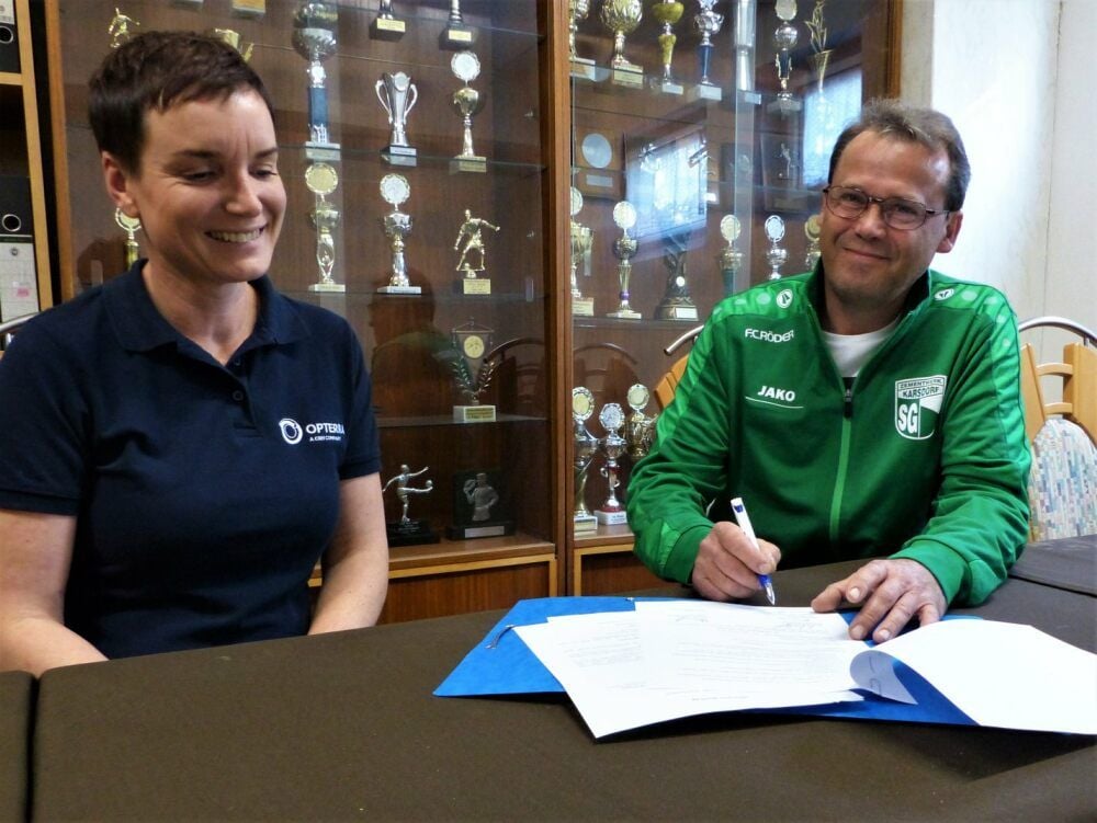 SG-Vorsitzender Thomas Liebert strahlt bei der Unterzeichnung des Sponsoringvertrages im Beisein von Anett Kuballa, Leiterin des Bereiches Umwelt und Genehmigungen im Opterra-Zementwerk Karsdorf.