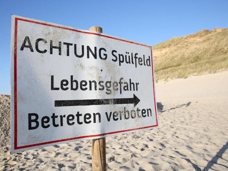 An einem Spülfeld am Strand von Kampen steht ein Schild mit der Aufschrift "Achtung Spülfeld - Lebensgefahr - Betreten verboten". Foto: Bodo Marks/dpa/Archiv