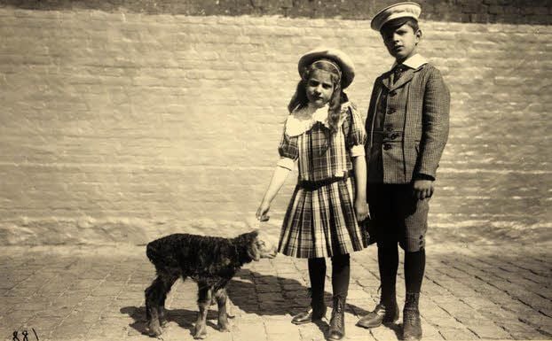 Gruppenbild mit einem Fettsteiß-Schaf: Die Professorenkinder Heinrich und Lilly stehen 1911 neben einem neugeborenen Lamm.