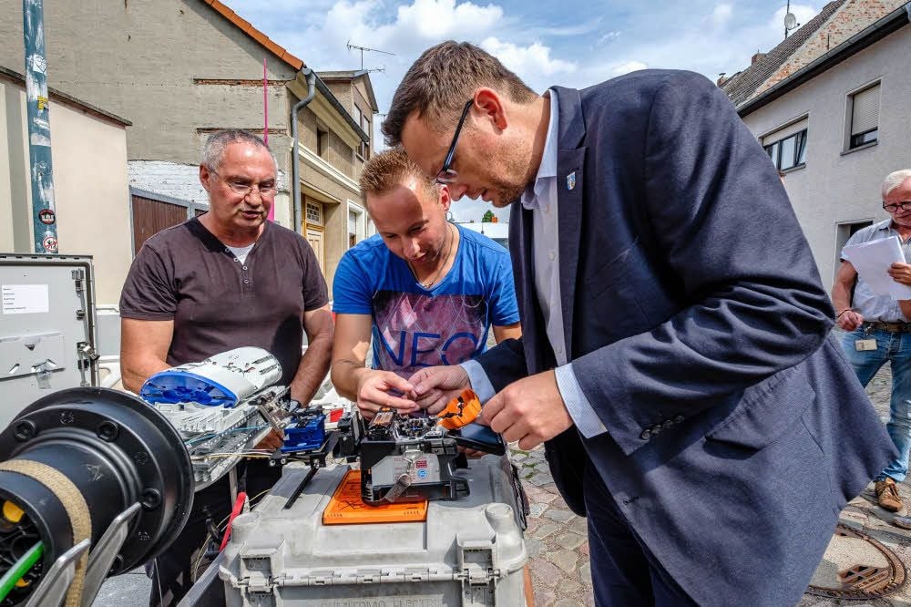 Bürgermeister Axel Clauß (rechts) verschweißte ein Glasfaserkabel und stellte den Anschluss an den Verteilerkasten damit her.