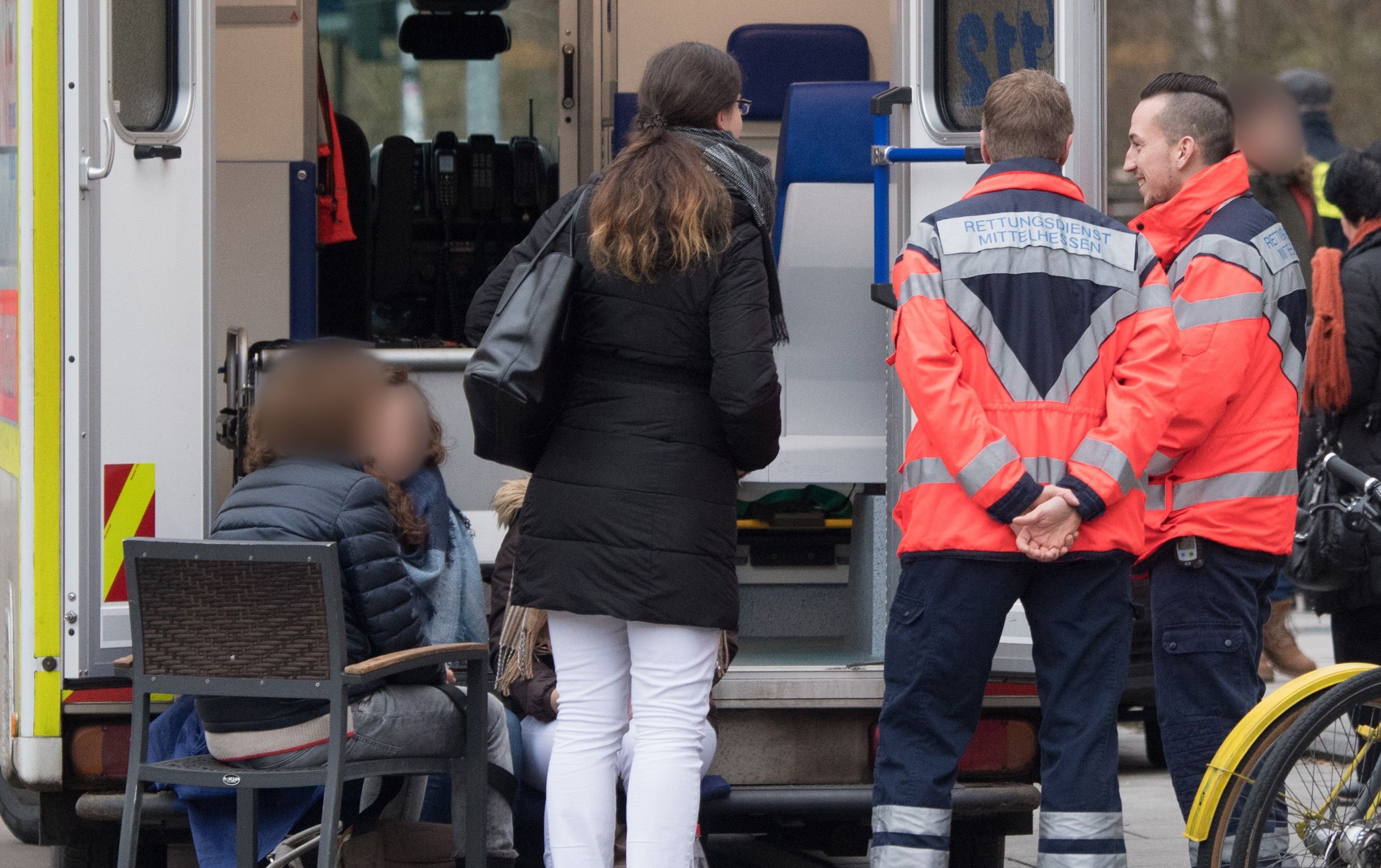 Nach einer Schiesserei in einer Arztpraxis in Marburg (Hessen) stehen Rettungskräfte vor dem Gebäude und betreuen unter Schock stehende Augenzeugen.