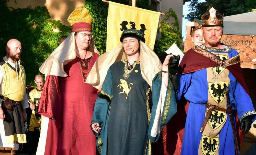 König Heinrich IV. (rechts) ist neben seinem Hofstaat zu sehen.