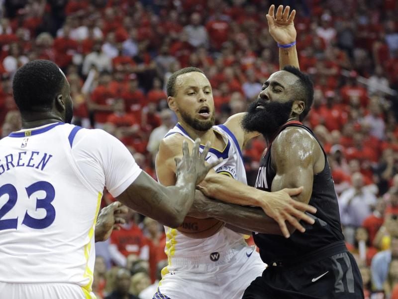 Stephen Curry (M) von Golden State foult Houstons James Harden. Foto: David J. Phillip/AP