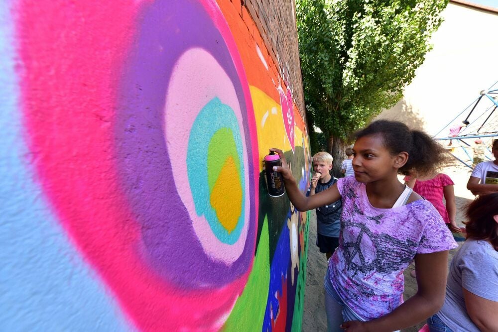 Bei der Gestaltung der Wand am Spielplatz in der Porsestraße Roßlau hat Tida pinkfarbene Blumen gesprüht.