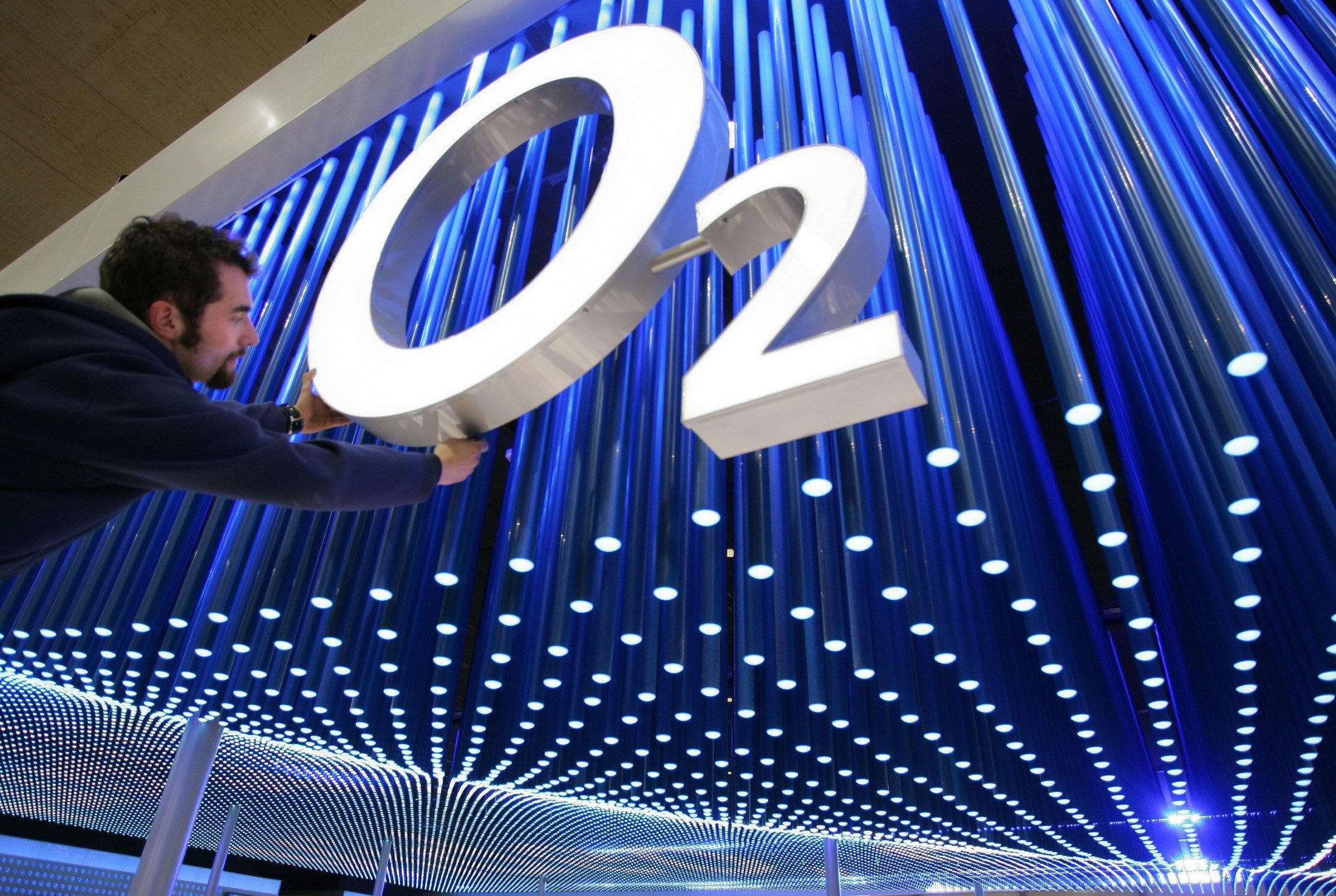 Ein Mann präpariert ein Logo von O2.