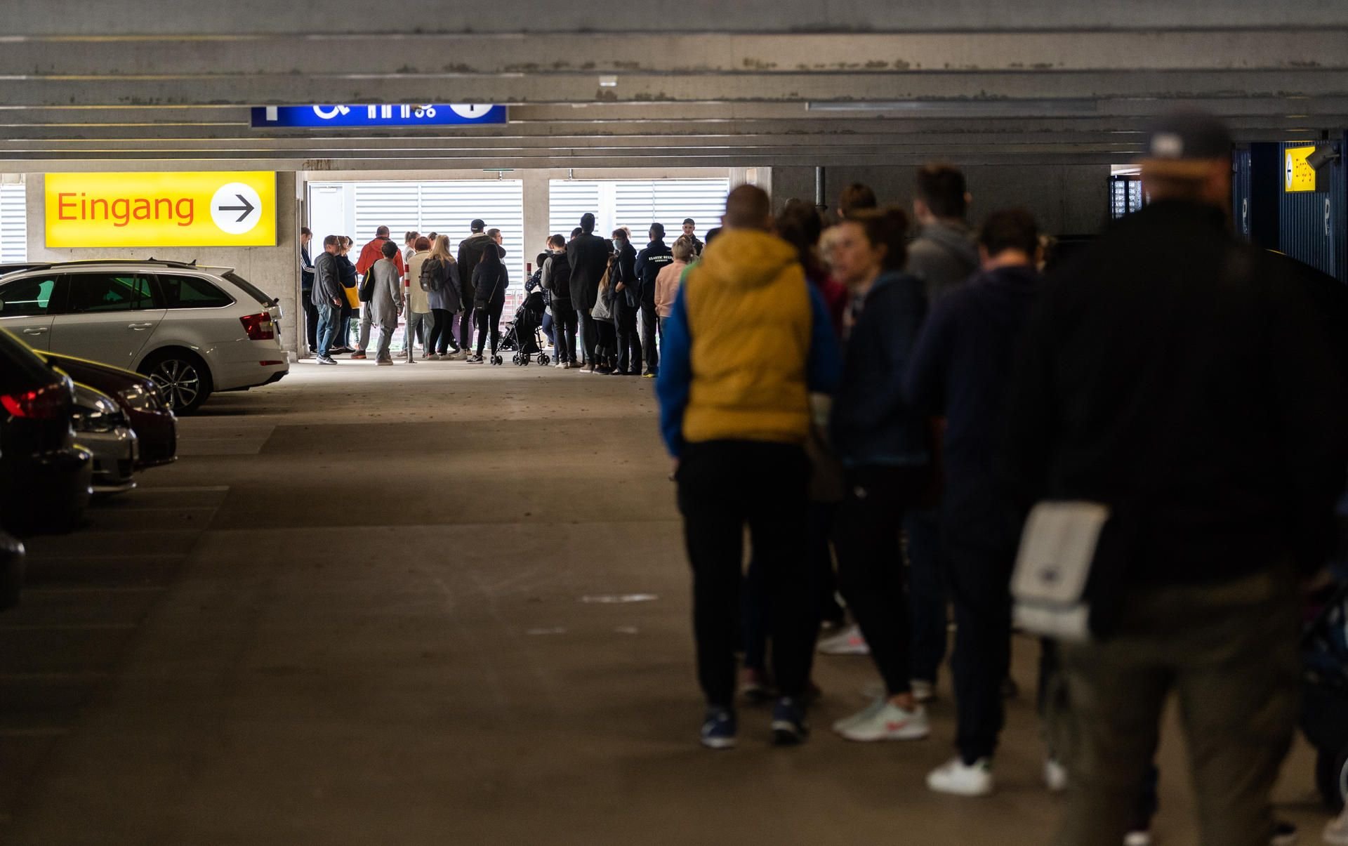 Kunden von IKEA stehen am Morgen vor dem Eingang der Filiale in einer Warteschlange bis in ein Parkhaus hinein.