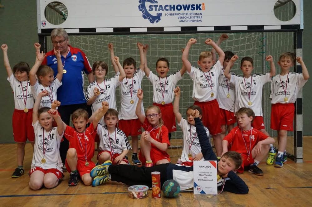 Die Minis des HC Burgenland freuen sich mit Trainer Hans Becker über den Turniersieg im heimischen Plotha.