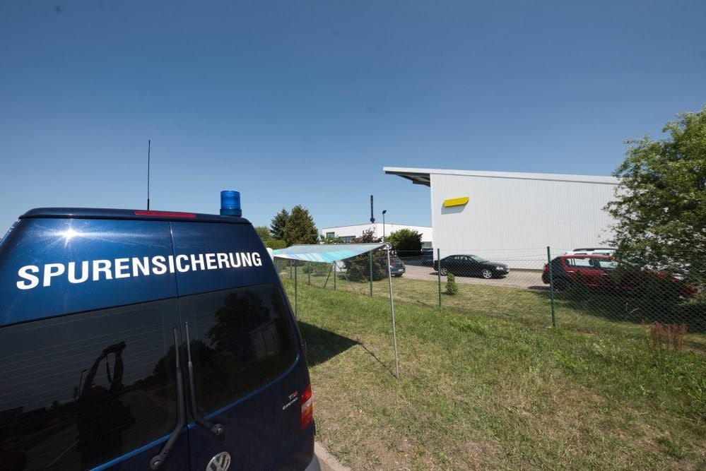 Ein Wagen der Spurensicherung ist an der Straße neben dem Entsorgungsunternehmen geparkt.