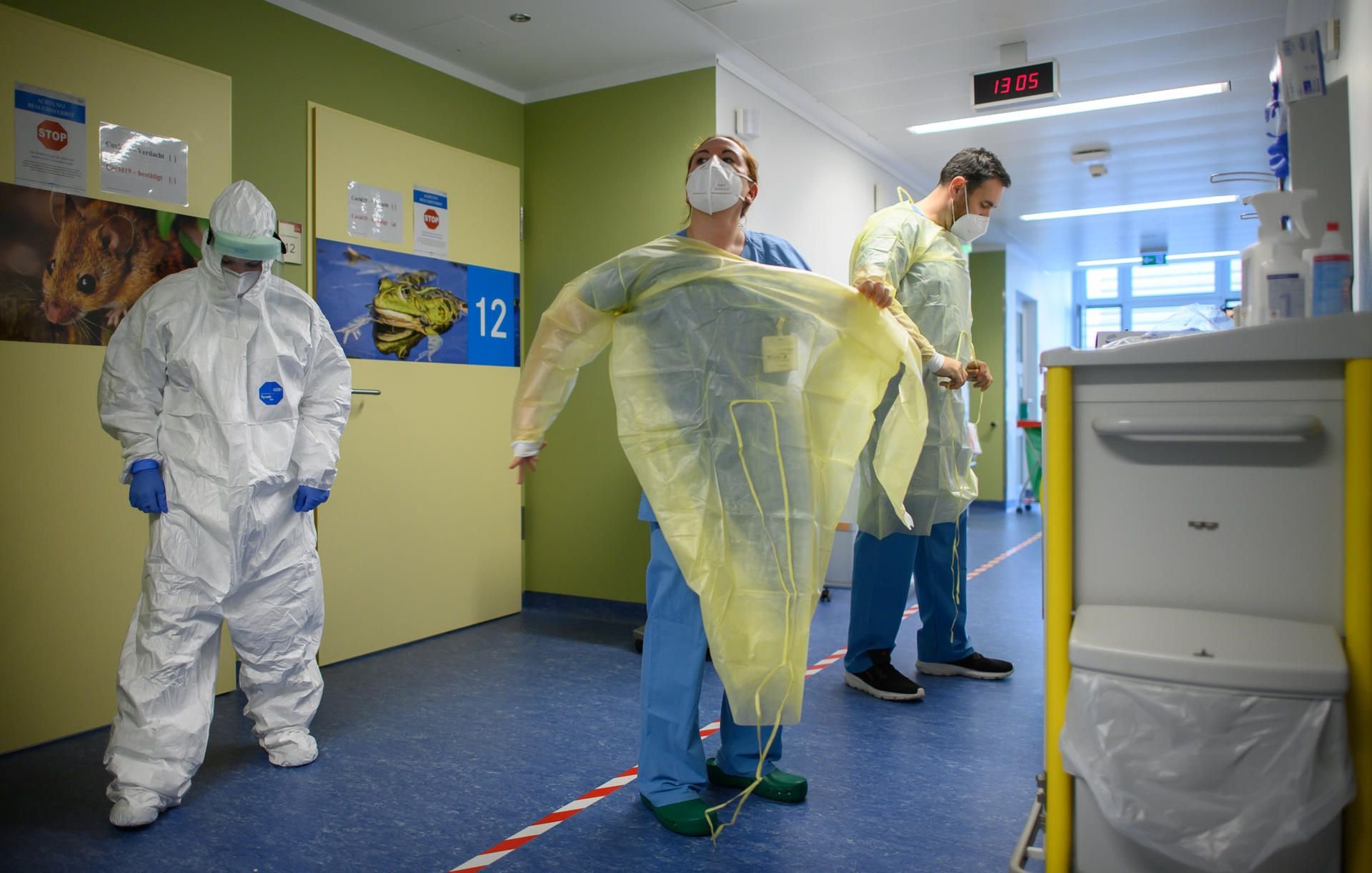Während eine Krankenpflegerin im Vollschutzanzug vor den Patientenzimmern wartet ziehen sich Soldaten der Bundeswehr auf der Corona-Station im Städtischen Klinikum Görlitz Virenschutzkittel an.