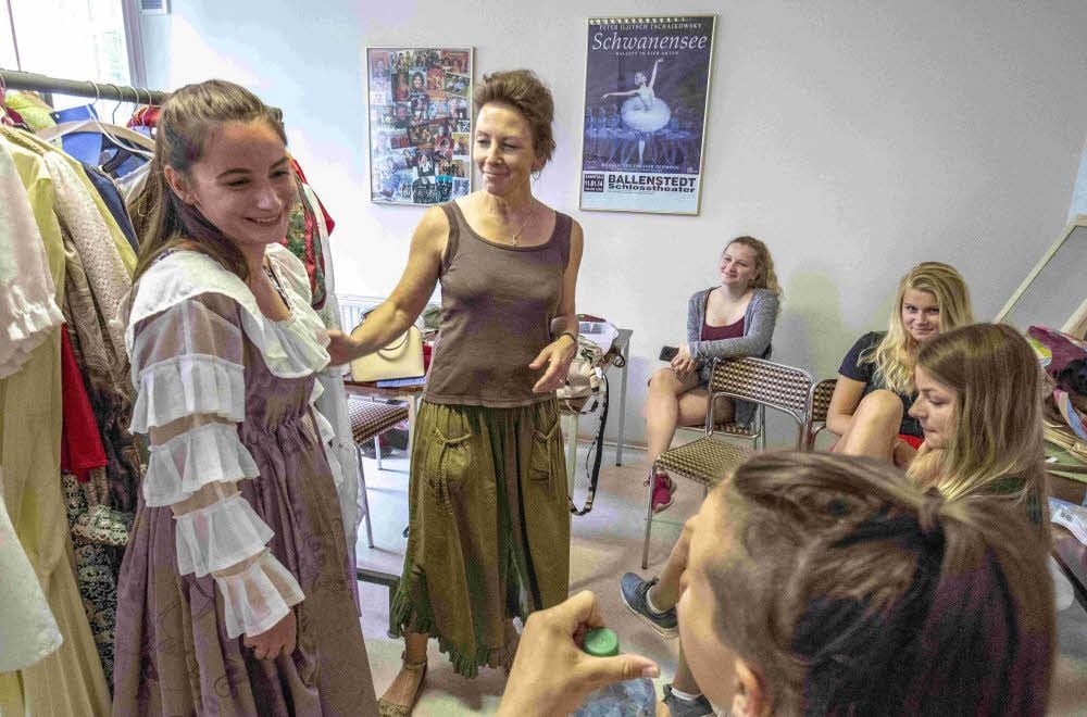 Bettina Sarapatta trifft mit ihren Schülern letzte Absprachen vor der Probe. Julia Jobst trägt schon ein Kostüm als Hochzeitsgast.