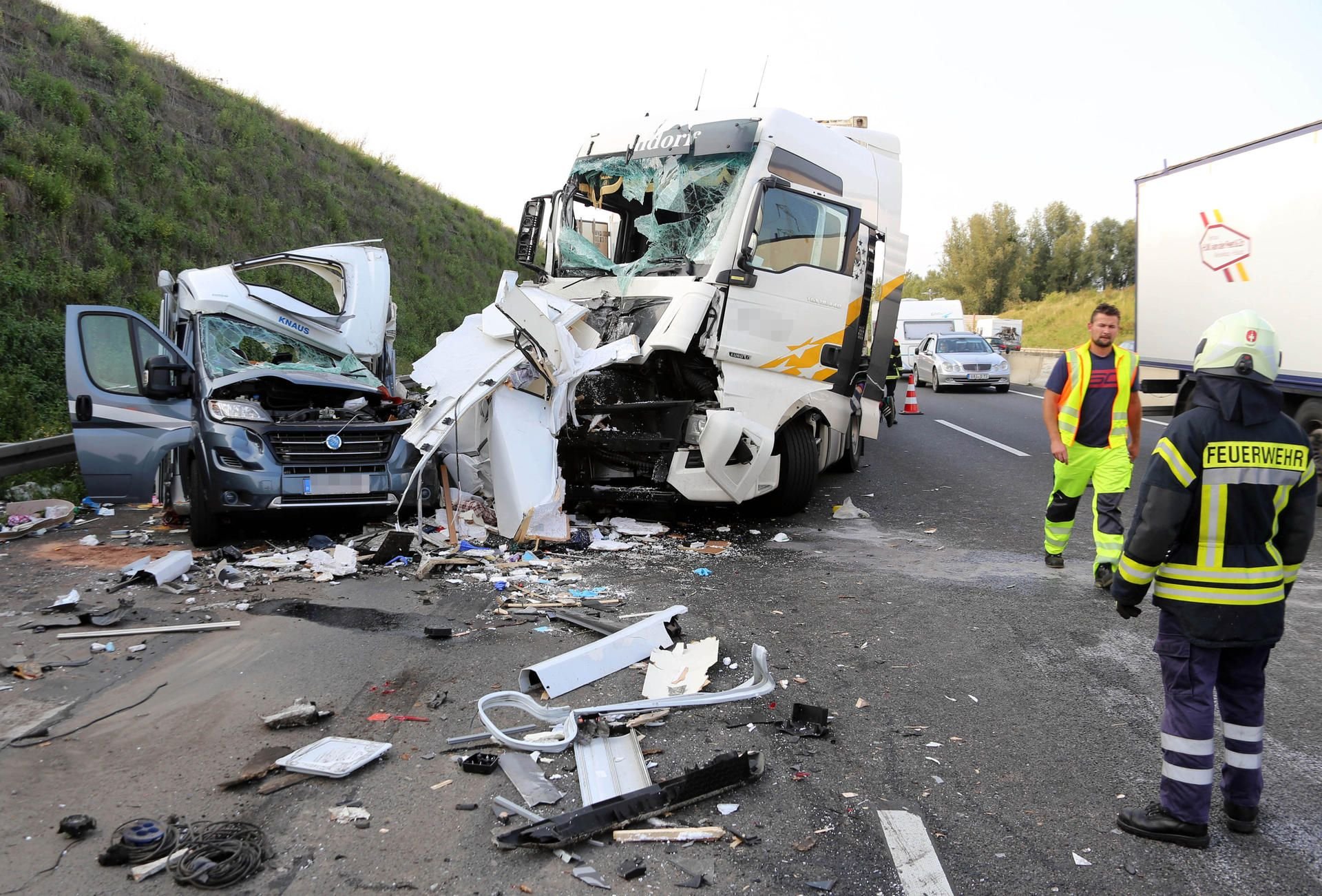 Die Überreste eines Wohnmobils stehen auf der Autobahn 7 bei Göttingen neben einem Lkw.