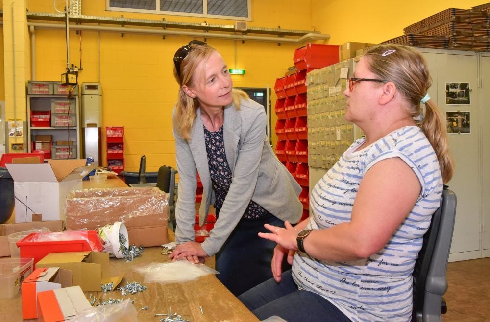 Werkstattbesuch: Christina Hensel im Gespräch mit Nadine Wesemann, die für Pino-Küchen Beschlagtüten bestückt.