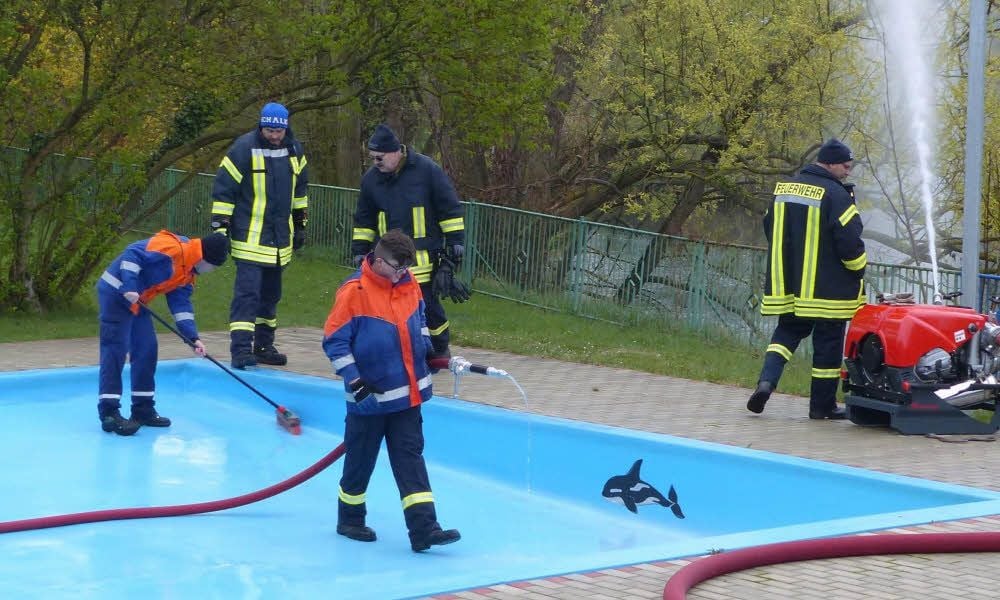 Wasser marsch: Mitglieder der Freyburger Jugendfeuerwehr säubern das Planschbecken.