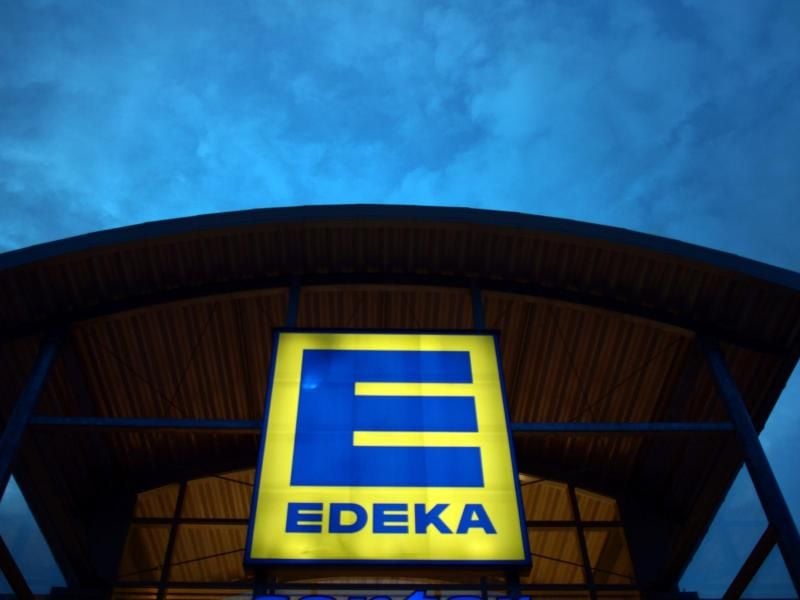 Eine Leuchtreklame weist auf einen Edeka-Markt hin. Foto: Federico Gambarini/dpa/Archivbild