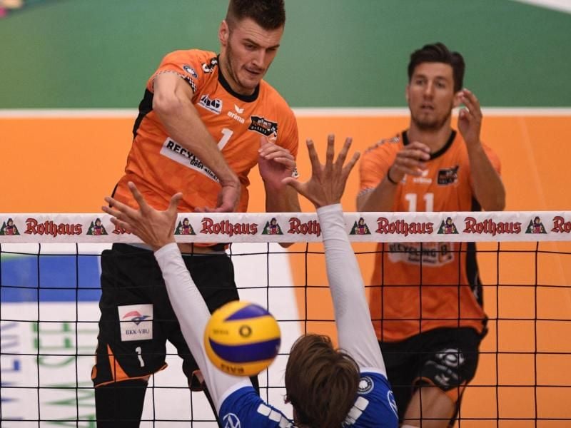 Berlins Aleksandar Okolic (l) schmettert den Ball über den Block von Friedrichshafens Andreas Takvam (unten). Foto: Felix Kästle