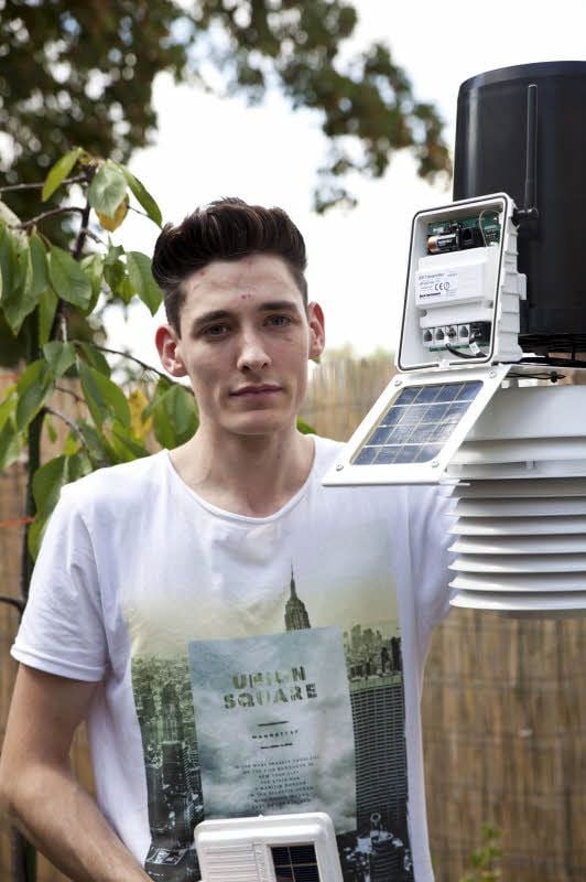 Justin Wenk kontrolliert im Garten den Sender seiner Außen-Wetterstation. Der schwarze Teil der Anlage misst die Menge der Niederschläge.