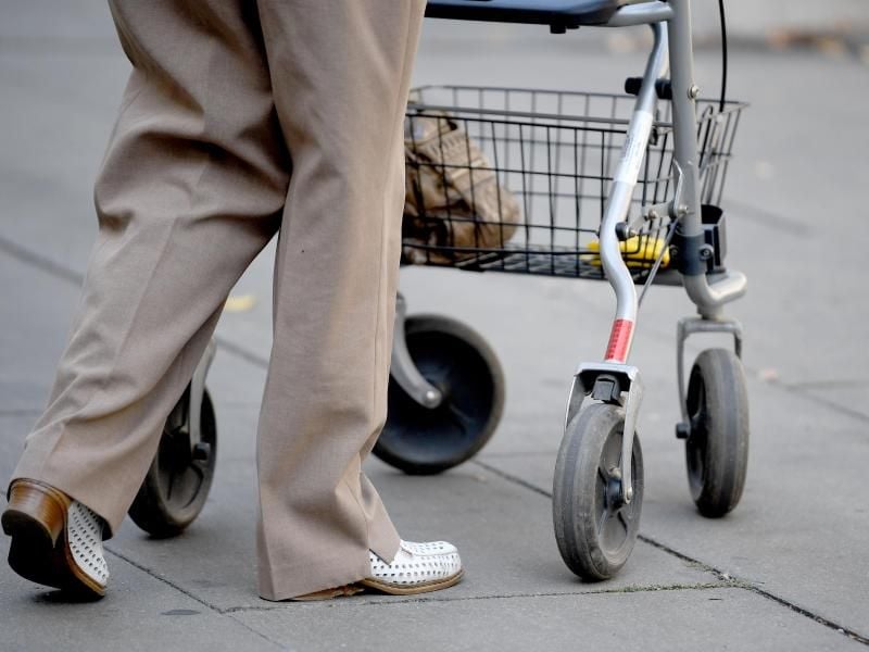 Eine alte Frau benutzt als Gehhilfe einen Rollator. Foto: Britta Pedersen/Archiv
