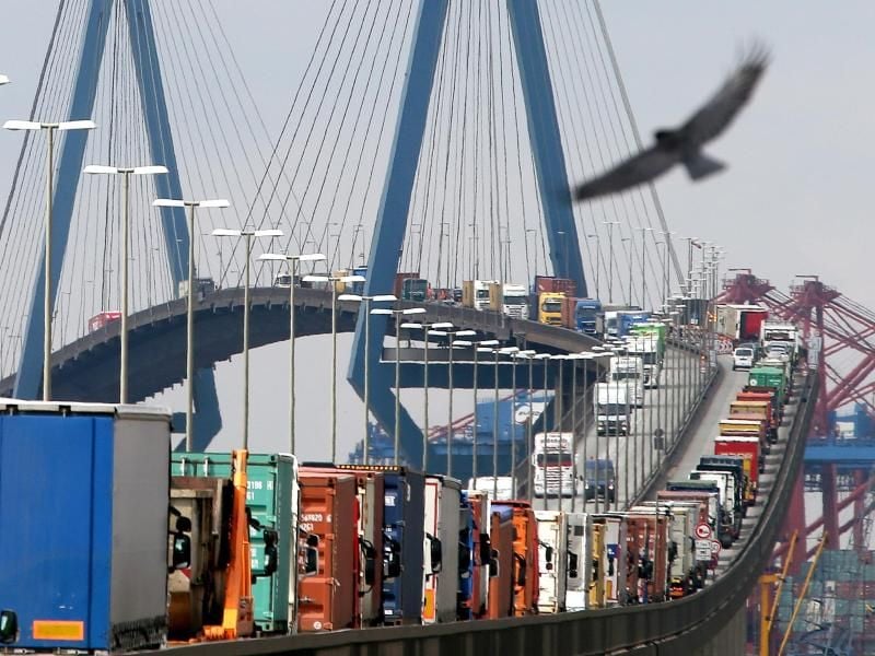 Mit Containern beladene Lastwagen stauen sich auf der Köhlbrandbrücke im Hafen. Foto: Christian Charisius/Archivbild