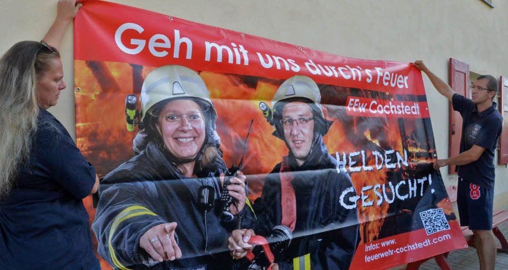 Kevin Krabiell und Anja Ahrendt-Krabiell beim Aufhängen der Banner im vergangenen Sommer.